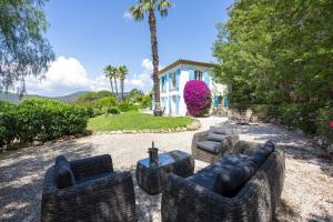 een patio met stoelen en een tafel voor een huis bij Golfvilla Riviera in Grimaud
