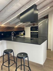 a kitchen with two stools and a counter with a sink at Casa Víctor in Albarracín +4 photos