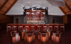 eine Bar mit einer Reihe von Barhockern in einem Raum in der Unterkunft Park Chalet, Shahdag, Autograph Collection in Shahdag