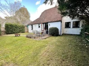a house with a table and chairs in the yard at Pass the Keys The Granary the perfect Country Cottage all year in Ashford
