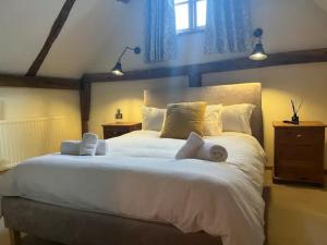 a bedroom with a large white bed with two towels on it at Pass the Keys The Granary the perfect Country Cottage all year in Ashford