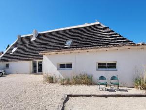 2 chaises devant une maison blanche dans l'établissement La Cabane du Boumian, à Saintes-Maries-de-la-Mer