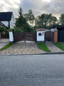 dom z drewnianym płotem i podjazdem w obiekcie Ferienwohnung Anna Swinemünde Rycerska w Świnoujściu