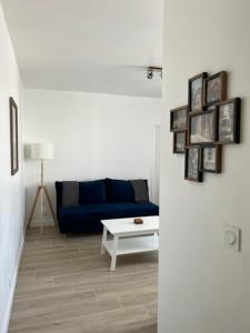 uma sala de estar com um sofá azul e uma mesa em Chez Jérôme et Dina em Aubervilliers