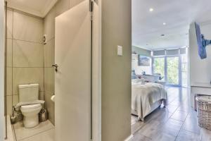 a bathroom with a toilet and a bed in a room at Hyde Park on the Square in Cape Town +13 photos