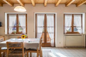 a dining room with a table and chairs and windows at Gasthaus Zur Linde- Napf in Oberried