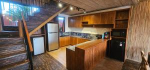 a kitchen with wooden cabinets and a staircase at Bamboo Estate Legian in Legian