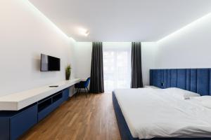a bedroom with a bed and a desk and a tv at Luxury Apartments “Bozdosh” in Uzhhorod