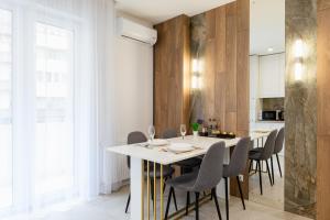 a kitchen and dining room with a white table and chairs at Luxury Apartments “Bozdosh” in Uzhhorod