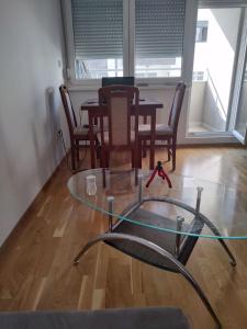 a glass table in a room with a table and chairs at Apartman in Mali Mokri Lug