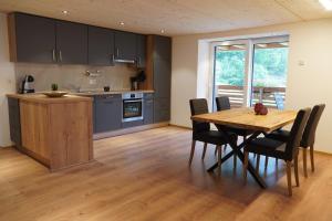 a kitchen and dining room with a wooden table and chairs at Ferienhaus Capricorn **** in Saas-Grund