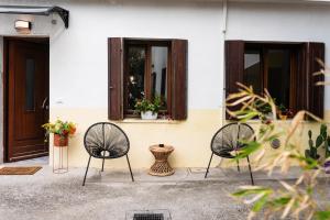 dos sillas sentadas frente a una casa en [Angolo45]Vista Inedita su Udine en Passons
