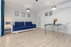 a living room with a blue couch and a table at Praga Apartment Łukowska by Renters in Warsaw