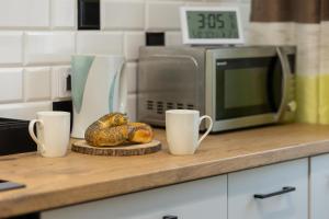 a counter top with two cups and a microwave at Praga Apartment Łukowska by Renters in Warsaw