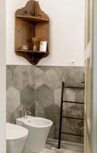 een badkamer met een wastafel, een toilet en een spiegel bij CASA ANGIOLINA - Casa vacanze con vista sulle colline in Govone