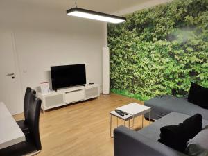 ein Wohnzimmer mit einem Sofa und einem Flachbild-TV in der Unterkunft Arbio Apartments near Yppenplatz & Brunnenmarkt in Wien