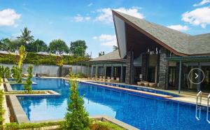 a large swimming pool next to a building at Villa Little Ubud in Gadok 1