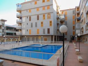ein Gebäude mit einem Pool neben einem Gebäude in der Unterkunft Apartment Asequin Beach in Torrevieja