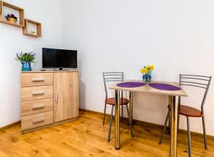 a room with a table and two chairs and a tv at Hostel Koral in Szczecin