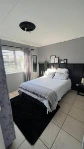 a bedroom with a large bed and a window at Family Holiday Home Rental in Port Elizabeth in Lorraine