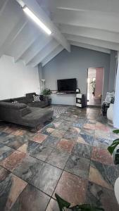ein Wohnzimmer mit einem Sofa und einem TV in der Unterkunft Family Holiday Home Rental in Port Elizabeth in Lorraine