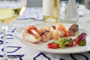 a plate of shrimp and vegetables on a table at Hotel Scalinatella in Capri
