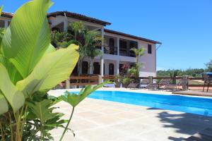 a villa with a swimming pool and a house at Pousada Encantos de Arraial in Arraial d'Ajuda
