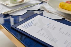 a menu on a table with a plate of food at Hotel Scalinatella in Capri