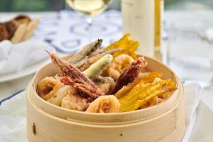 a wooden bowl filled with shrimp and other foods at Hotel Scalinatella in Capri