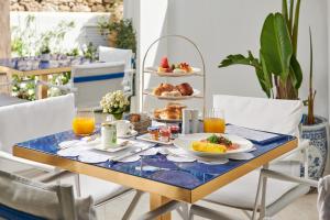 a breakfast table with breakfast foods and orange juice at Hotel Scalinatella in Capri