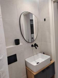 uma casa de banho com um lavatório branco e um espelho. em Modi Stay em Tessalônica