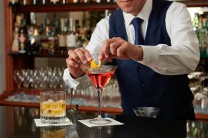 a bartender mixing a drink in a martini glass at Hotel Scalinatella in Capri