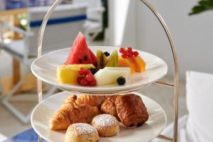 a three tiered plate of fruit and pastries and pastries at Hotel Scalinatella in Capri