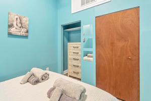 niebieska sypialnia z łóżkiem i drewnianymi drzwiami w obiekcie Broad Street Apartment w Filadelfii