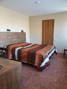 una camera d'albergo con un letto e una porta di Šolena a Alytus