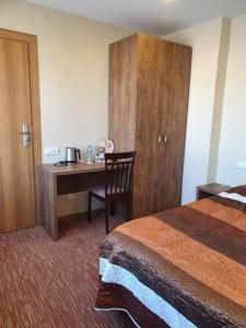 um quarto de hotel com uma cama e uma secretária em Šolena em Alytus