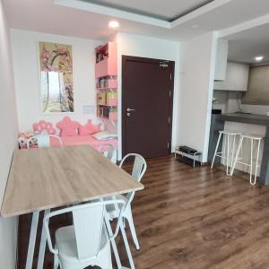 een keuken en een woonkamer met een tafel en stoelen bij Mupify Homestay Jazz Suites 4 in Kuching