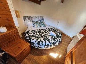 a bedroom with a bed and a wooden floor at Refugio Finca El Canu in Valdaliga 