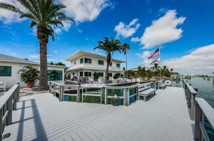 a dock with a house and palm trees at The Roth Hotel, Treasure Island, Florida in St Pete Beach