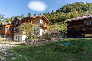 a house in the mountains with a stone wall at Maso Gigi in Castel Ivano
