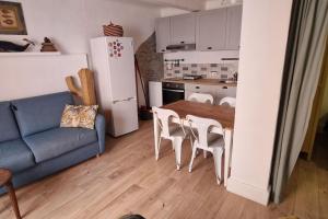 a kitchen with a blue couch and a table and chairs at Studio cosy à Collioure à deux pas de la plage et du centre in Collioure