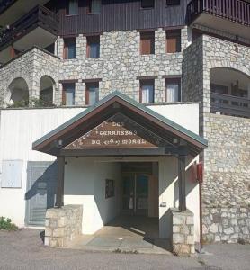 a entrance to a building with a sign on it at terrasses du Morel in La Lechere +1 photo