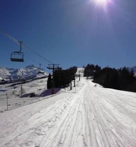 une piste de ski couverte de neige avec une remontée mécanique dans l'établissement terrasses du Morel, à La Lechere