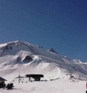 d'une montagne enneigée avec un lodge de ski. dans l'établissement terrasses du Morel, à La Lechere