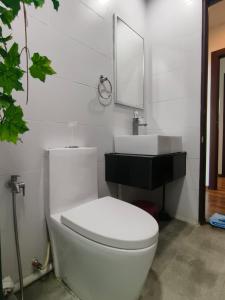een badkamer met een wit toilet en een wastafel bij Mupify Homestay Jazz Suites 4 in Kuching