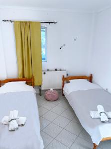 two beds in a room with yellow curtains at Jacque's Boutique Suite in Thessaloniki