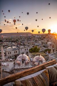 um grupo de balões de ar quente sobrevoando uma cidade em Charming Cave Hotel em Goreme