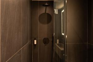 y baño con ducha y puerta de cristal. en Taskou Luxury Suites en Tesalónica