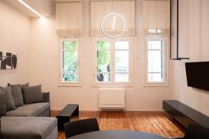 salon z kanapą i dwoma oknami w obiekcie Taskou Luxury Suites w Salonikach
