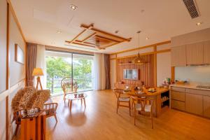 een keuken en een woonkamer met een tafel en stoelen bij Maha Mangala Zen Garden & Residence in Da Nang